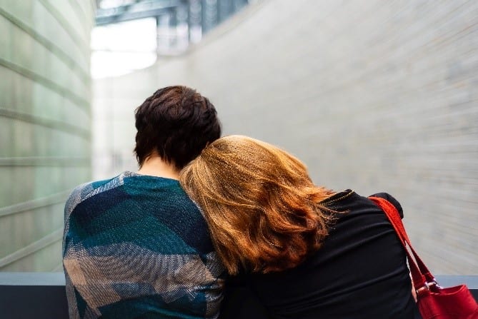 Two women leaning on each other